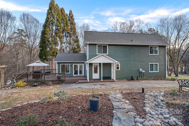 view of front of property with roof with shingles and a deck
