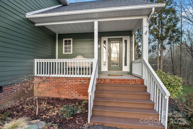 property entrance with covered porch and roof with shingles