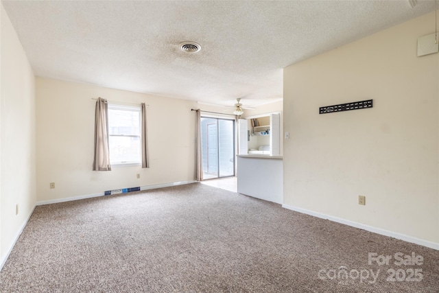 empty room featuring ceiling fan, a textured ceiling, and carpet flooring