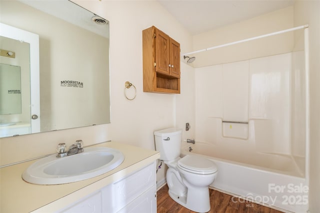 full bathroom featuring vanity, hardwood / wood-style floors, shower / washtub combination, and toilet