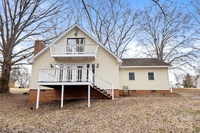 rear view of house featuring a balcony and a wooden deck