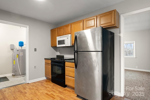 kitchen featuring light wood-type flooring, water heater, stainless steel refrigerator, and electric range