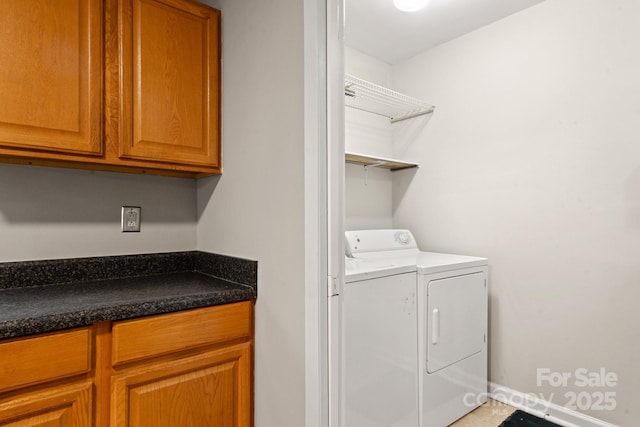 clothes washing area with independent washer and dryer and cabinets