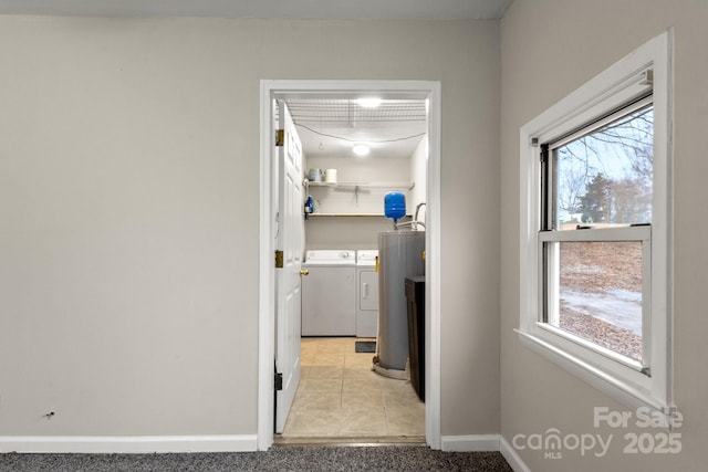 washroom featuring independent washer and dryer, water heater, and light colored carpet