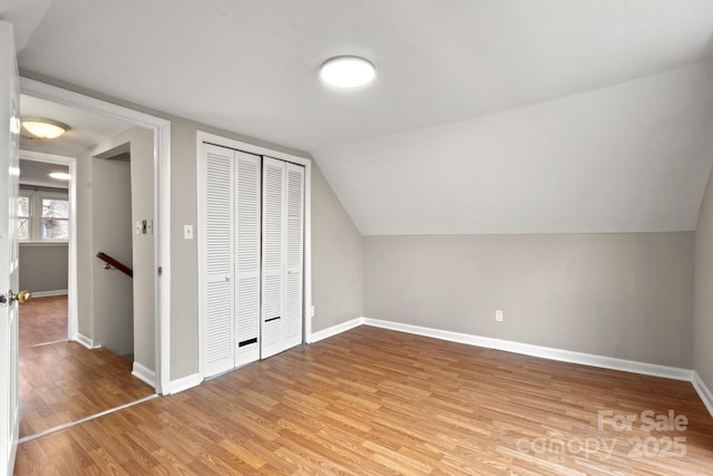 additional living space featuring vaulted ceiling and hardwood / wood-style floors