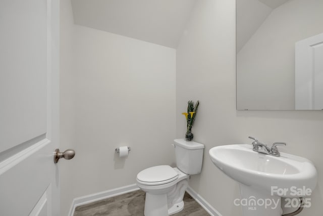 bathroom featuring a sink, toilet, and baseboards