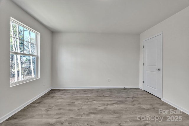 unfurnished room featuring baseboards and wood finished floors