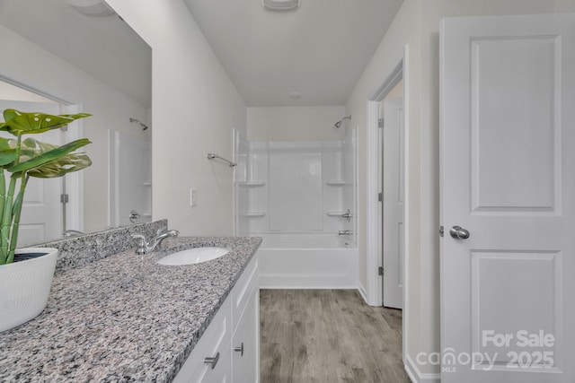 full bath with shower / bathing tub combination, vanity, and wood finished floors