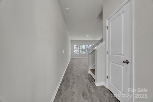 hall with wood finished floors, baseboards, and stairs