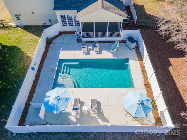 view of swimming pool featuring a patio area and a sunroom