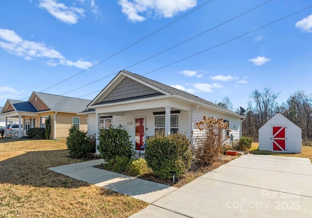 view of front of home featuring covered porch, a front yard, and a storage unit