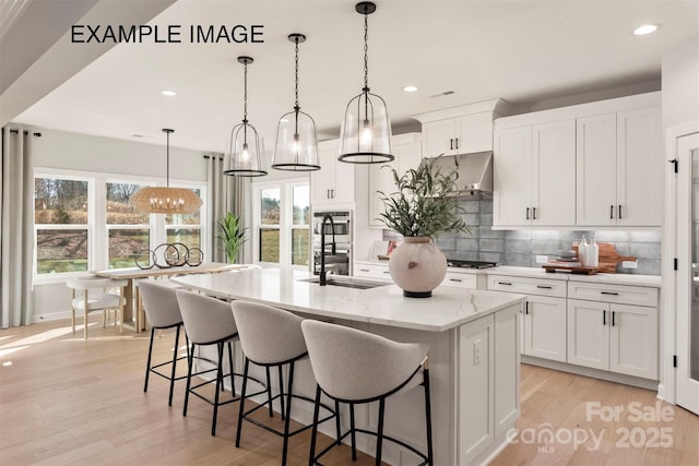 11016 Tyler Brook Ln Unit Oak0036, Mint Hill, NC 28227 - kitchen featuring recessed lighting, a center island with sink, light wood finished floors, tasteful backsplash, and white cabinetry