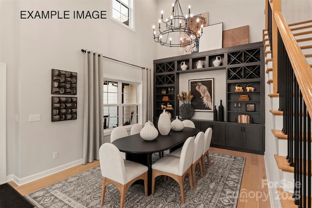 11016 Tyler Brook Ln Unit Oak0036, Mint Hill, NC 28227 - dining space featuring a chandelier, light wood-style floors, stairs, and a high ceiling