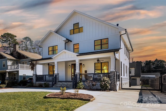 modern farmhouse style home with a lawn, ceiling fan, and a porch