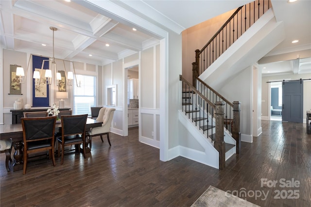 dining space with coffered ceiling, a notable chandelier, beamed ceiling, dark hardwood / wood-style flooring, and a barn door