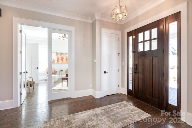 entrance foyer with a notable chandelier, dark hardwood / wood-style floors, and ornamental molding