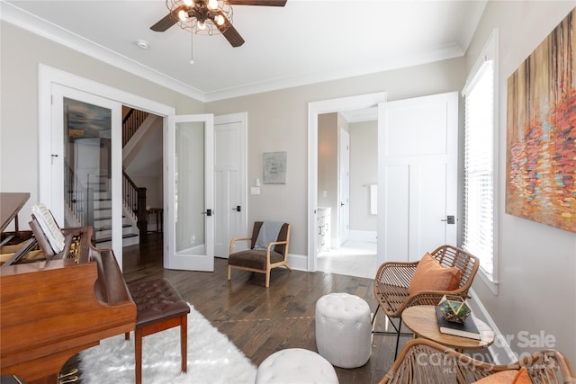 living area featuring dark hardwood / wood-style flooring, ceiling fan, crown molding, and french doors