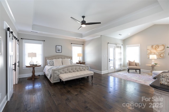 bedroom with dark hardwood / wood-style flooring, a barn door, a tray ceiling, ornamental molding, and ceiling fan