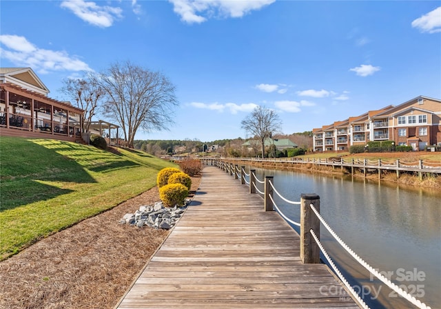 view of dock featuring a water view and a yard