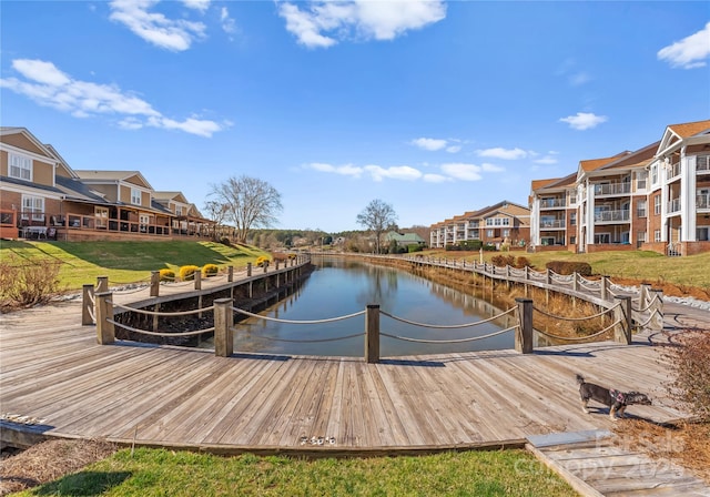 dock area with a lawn and a water view