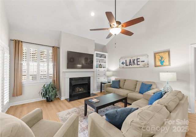 living room with ceiling fan, lofted ceiling, and light hardwood / wood-style floors