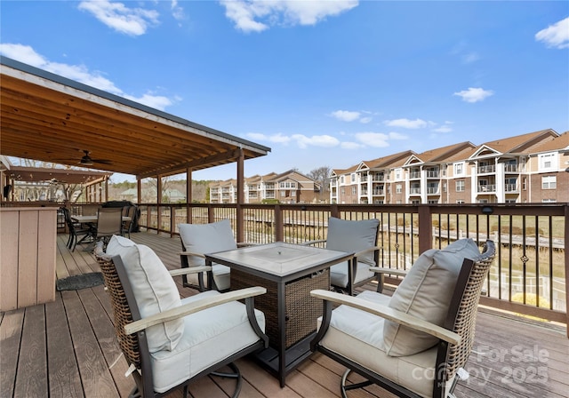 deck with ceiling fan and a fire pit