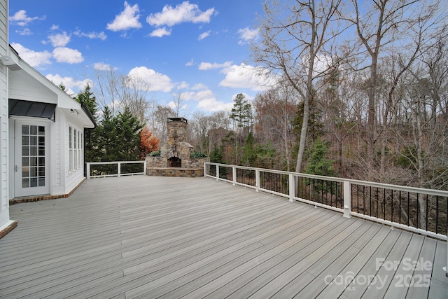 wooden terrace featuring an outdoor stone fireplace