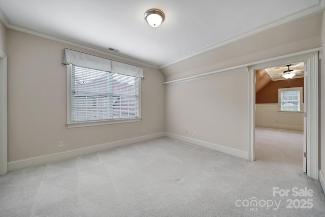 unfurnished room featuring crown molding, lofted ceiling, carpet floors, ceiling fan, and visible vents