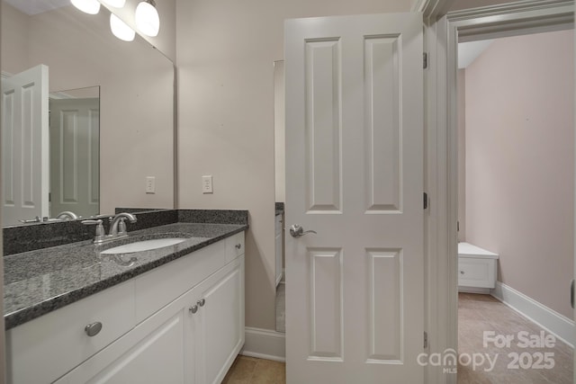 bathroom with baseboards, tile patterned flooring, and vanity