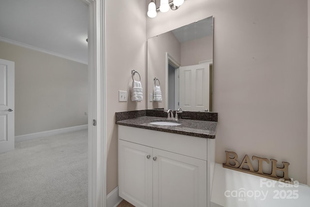 bathroom featuring vanity, ornamental molding, and baseboards