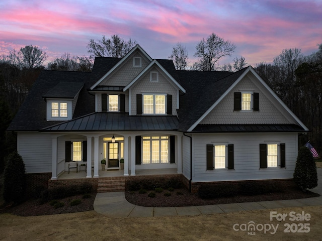 view of front facade with metal roof, a standing seam roof, and a porch