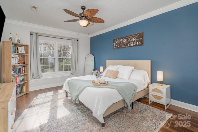 bedroom with a textured ceiling, crown molding, ceiling fan, and wood-type flooring