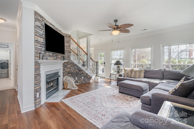 living room with a fireplace, washer / clothes dryer, hardwood / wood-style floors, and crown molding