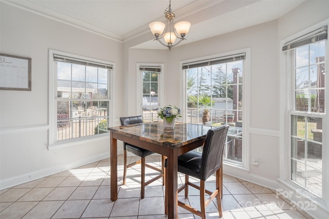 dining area with crown molding, light tile patterned flooring, and a notable chandelier