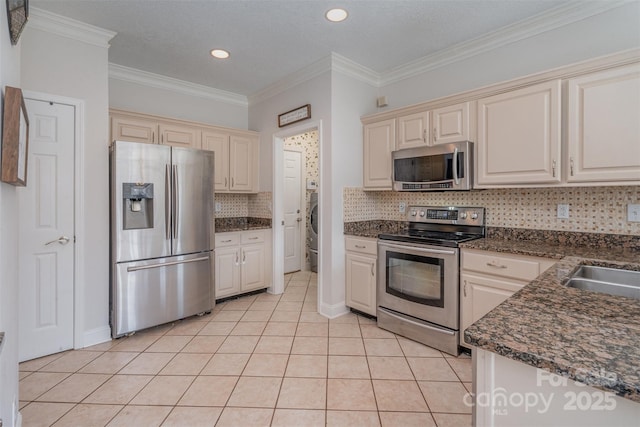 kitchen featuring stainless steel appliances, sink, ornamental molding, light tile patterned flooring, and decorative backsplash