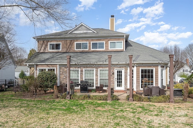 rear view of house featuring a patio and a yard