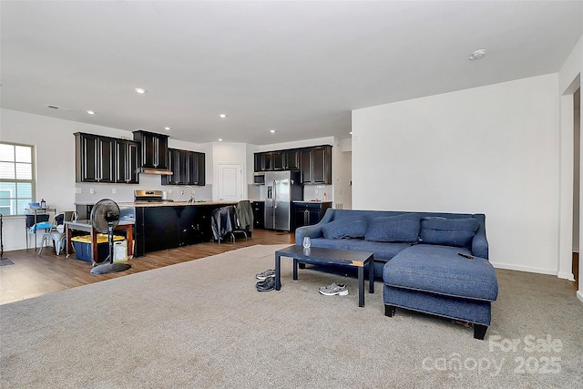 living area featuring recessed lighting, wood finished floors, visible vents, baseboards, and carpet