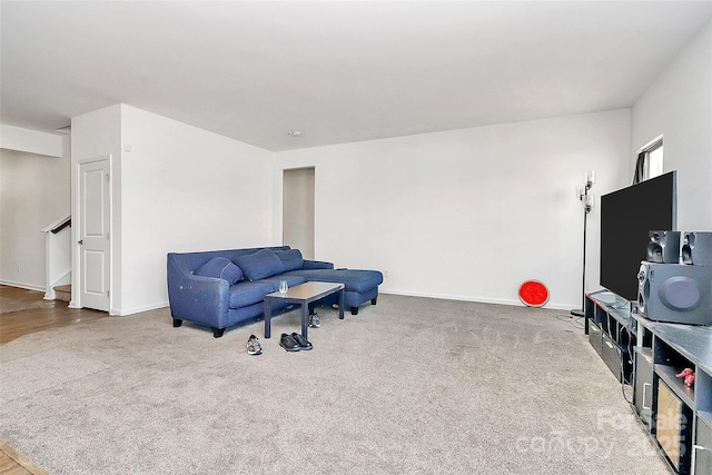 sitting room featuring carpet floors, baseboards, and stairway