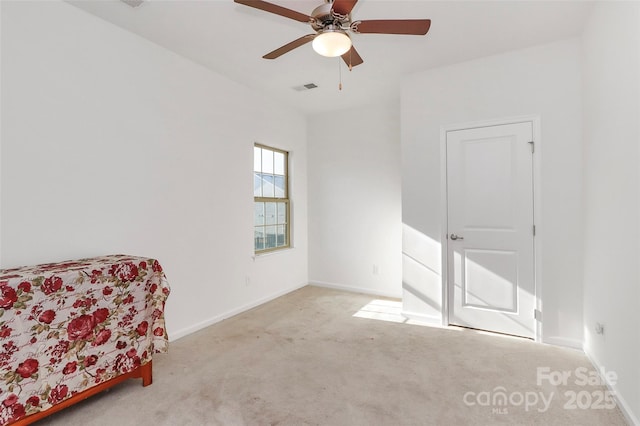 interior space featuring a ceiling fan, light colored carpet, visible vents, and baseboards