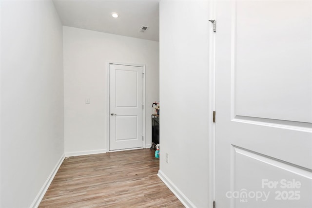 hallway featuring baseboards, recessed lighting, visible vents, and light wood-style floors