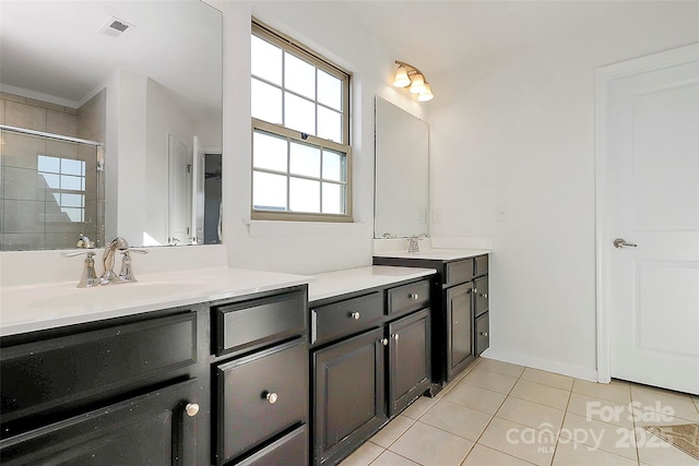 full bathroom featuring visible vents, a sink, tile patterned flooring, a shower stall, and two vanities