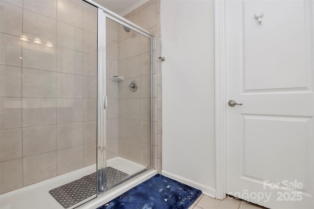 bathroom featuring a stall shower, baseboards, and tile patterned floors