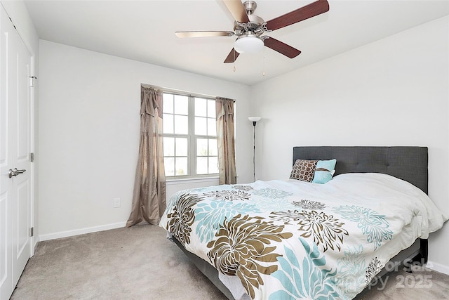 bedroom featuring light colored carpet, ceiling fan, and baseboards