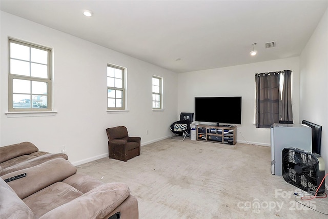 living area featuring light carpet, visible vents, and baseboards