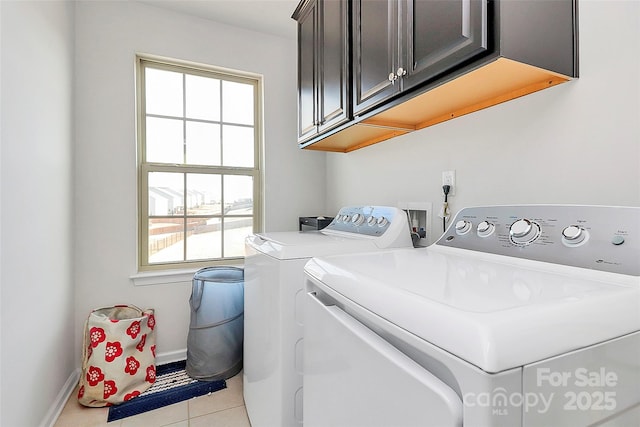 washroom with baseboards, cabinet space, washing machine and clothes dryer, and light tile patterned floors