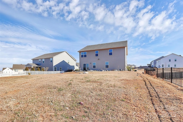 back of house featuring fence and a residential view