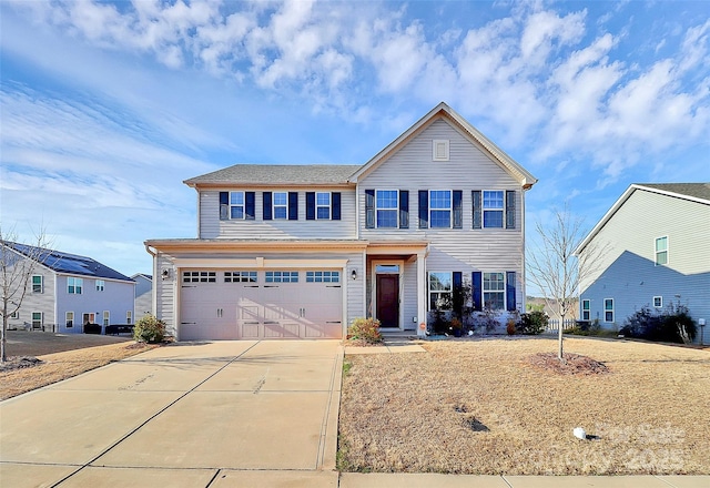 traditional-style house featuring a garage and concrete driveway