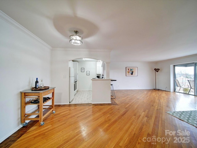 unfurnished living room with arched walkways, crown molding, decorative columns, and light wood-type flooring
