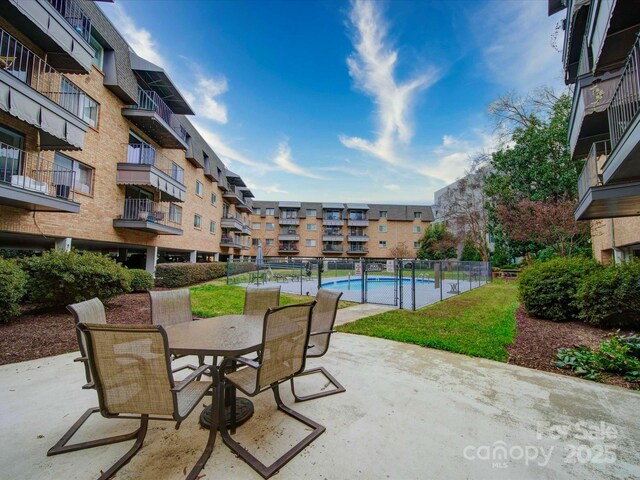 community pool featuring outdoor dining space and a patio
