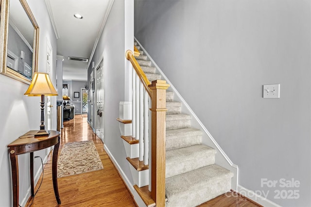 stairway with recessed lighting, wood finished floors, visible vents, and baseboards